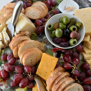 Flavored Cheese Board caramelized onion, and truffle with olives and sliced baguette
